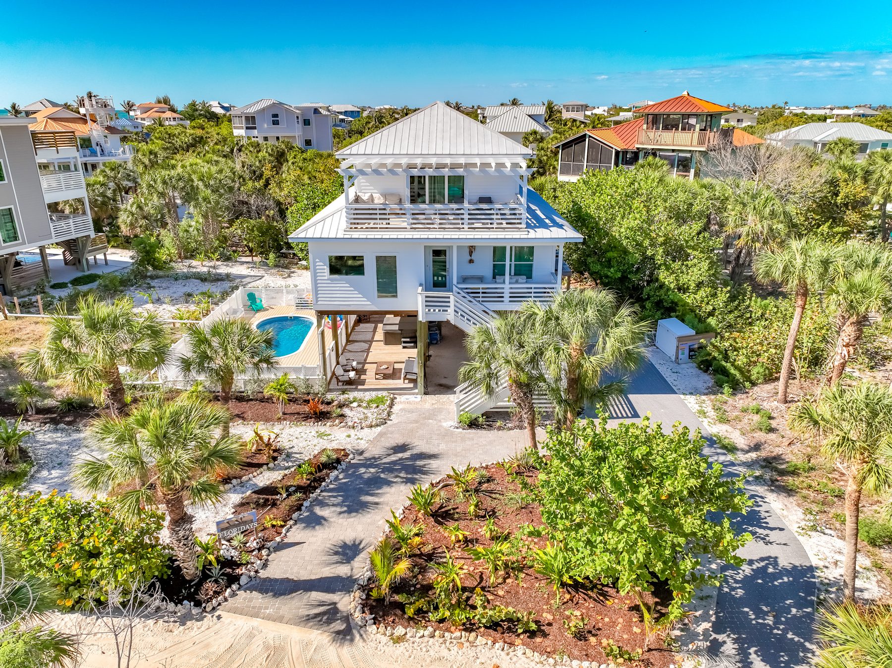 Coconut Cottage from above — white stilt home with heated pool